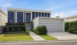 A modern building with large windows, a garage, and well-maintained landscaping.