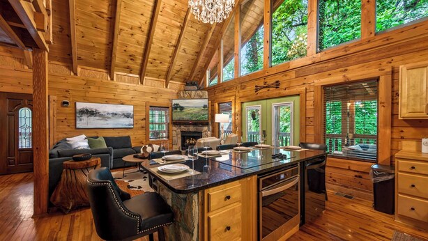 L’intérieur d’un chalet en bois comprend un coin repas, une cuisine et de grandes fenêtres.