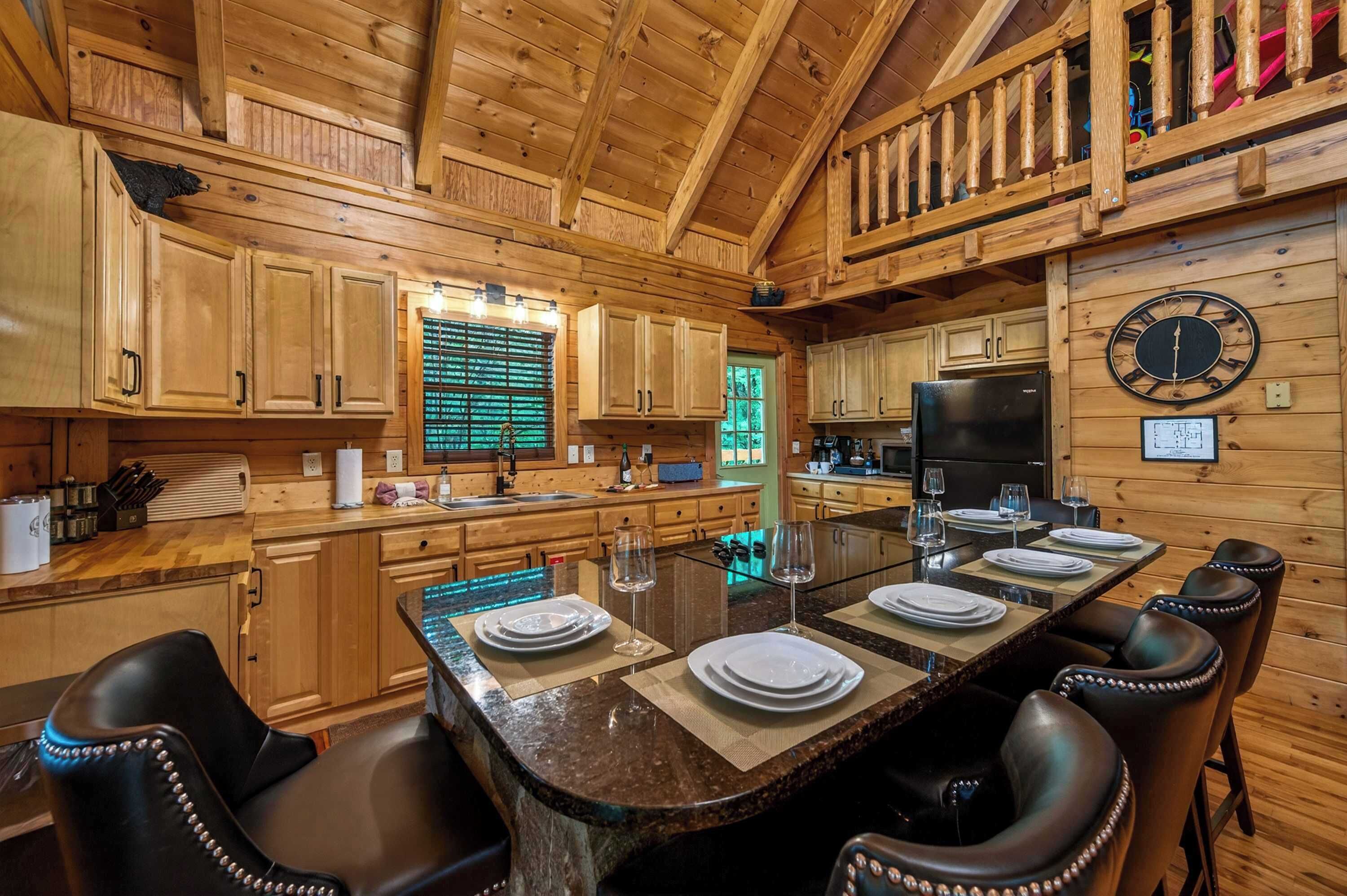 Une cuisine de style rustique, avec des éléments en bois, comprenant un îlot central, des placards en bois et un coin repas avec des chaises.