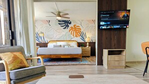 Une chambre d’hôtel moderne équipée d’un lit, d’un canapé, d’une télévision et d’une armoire en bois.