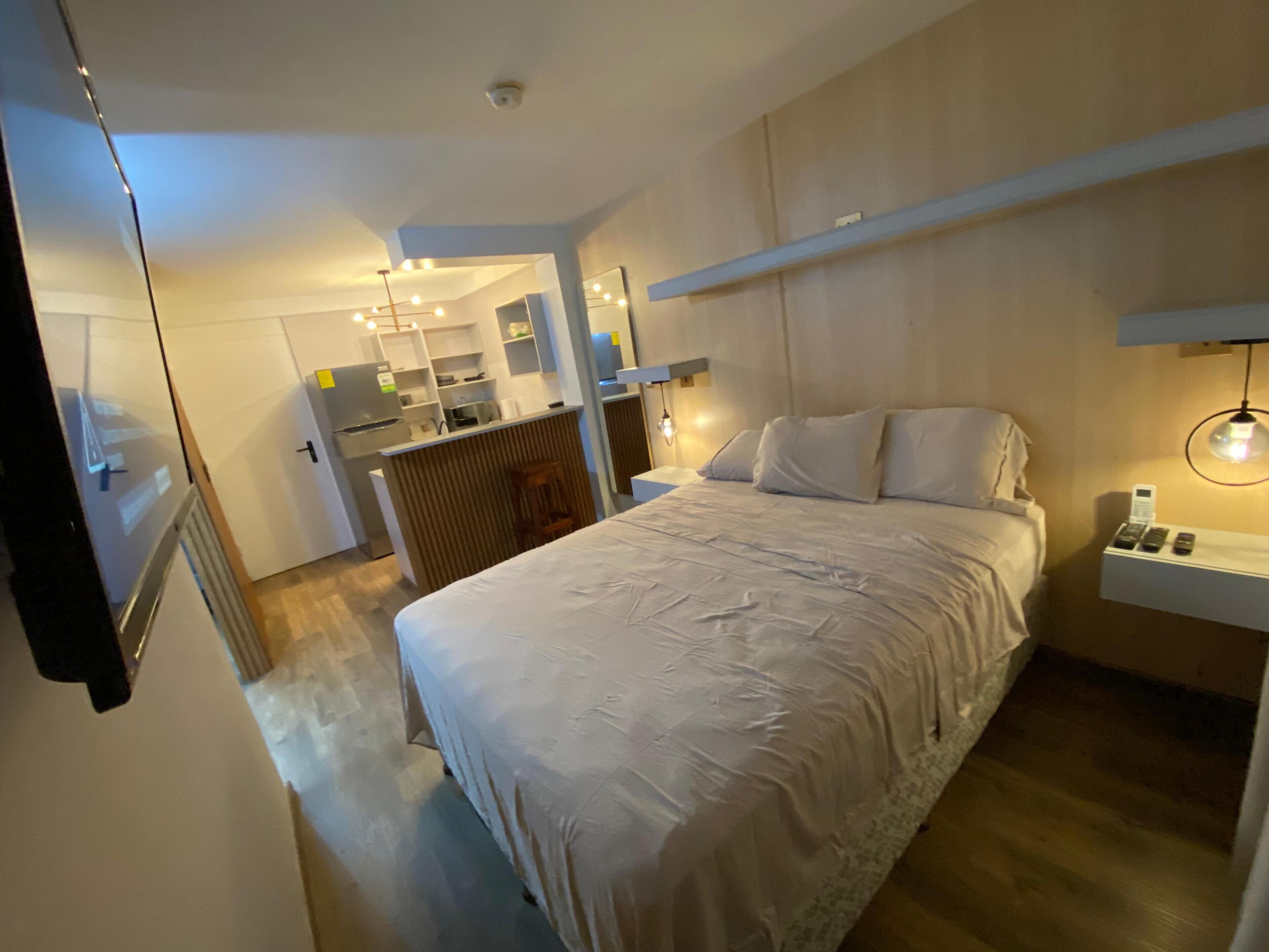 Ein Schlafzimmer mit Bett, Nachttisch und einem kleinen Schreibtisch mit Stuhl.