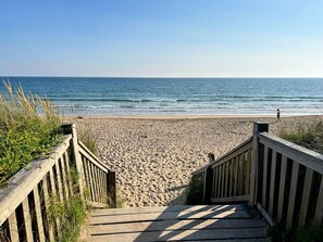 A wooden staircase leading to a sandy beach with the ocean in the background. - Ker Soazig - GUIDEL - Gîte (GUIDEL)