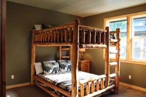 Un lit superposé avec une structure en bois et une couvre-lit à motifs.