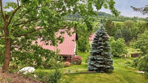 A rural landscape with a large tree, a red-roofed building, and a coniferous tree. - Apartment Černý by Interhome (Rokytnice nad Jizerou)