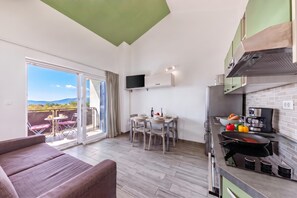 Eine moderne Küche mit Essbereich, einem Flachbildfernseher und einem Balkon mit schöner Aussicht.