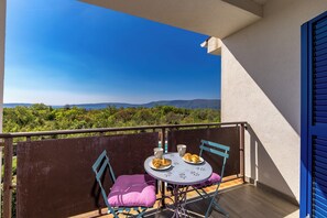Ein Balkon mit Tisch, Stühlen und Croissants.