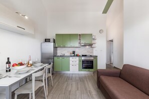 Eine kompakte Küche mit Essbereich, einer Mikrowelle, einem Kühlschrank und einem Backofen.