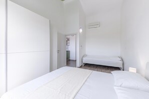 A bedroom with a bed, a wardrobe, and a small seating area. - Wabi Sabi Apt8 Pool & Sea View, Brzac, Croatia (Brzac)