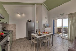 Eine moderne Küche mit Essbereich, einem Kühlschrank und Blick ins Freie.