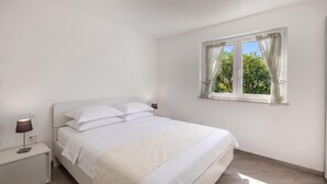 A bedroom with a bed, bedside tables, a lamp, and a window with curtains. - Wabi Sabi Apt2 Pool & Garden, Brzac, Croatia (Brzac)