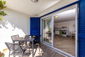 A modern kitchen with white cabinets and a dining area with a table and chairs. - Wabi Sabi Apt2 Pool & Garden, Brzac, Croatia (Brzac)