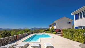 A swimming pool with lounge chairs, a stone wall, and a view of mountains. - Wabi Sabi Apt2 Pool & Garden, Brzac, Croatia (Brzac)