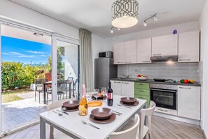 A modern kitchen with a dining area, large windows, and a view of the outdoors. - Wabi Sabi Apt1 Pool & Garden, Brzac, Croatia (Brzac)