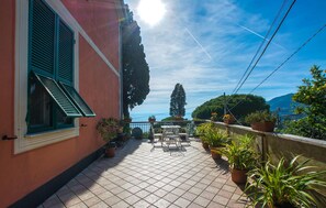 Un balcone con piante in vaso, mobili da esterno e vista sul mare.