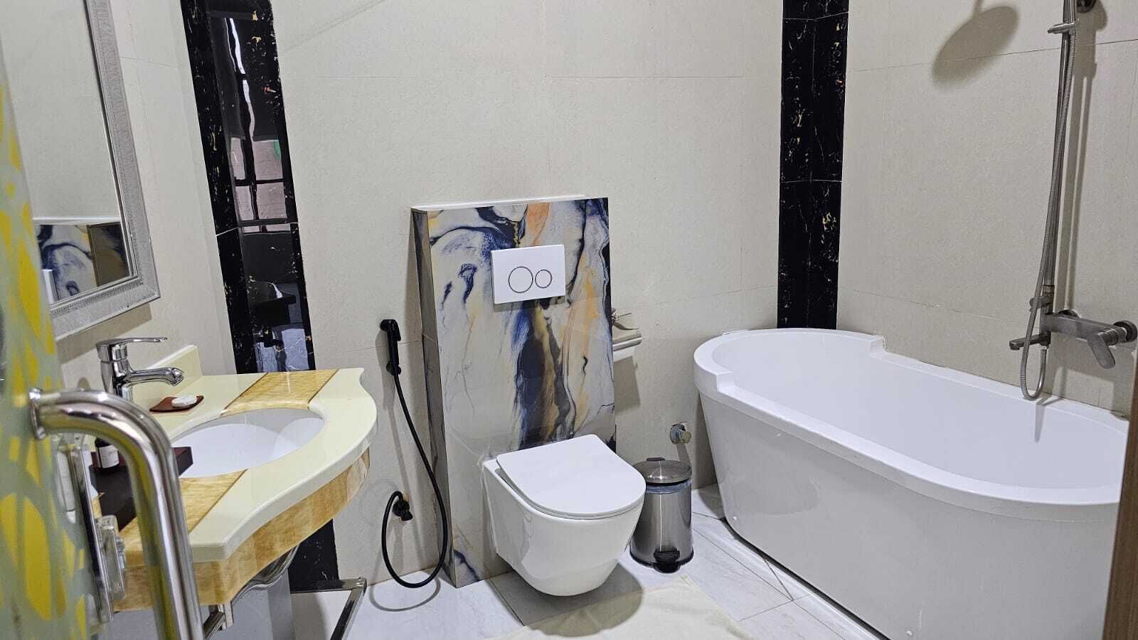 Un baño con inodoro, lavabo y bañera.