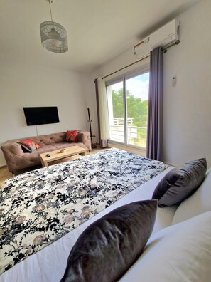 A bedroom with a bed, a sofa, a TV, and a window with curtains. - Villa joudia Royal golf Fès (Fès)