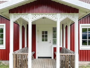 A red building with a white porch and a white door. - 5 Person Holiday Home in Kristdala (Kristdala)