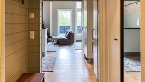 A hallway leading to a living area with a sofa, a coffee table, and a rug.