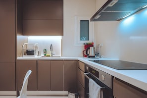 Eine moderne Küche mit Einbauofen, Kaffeemaschine und einem Fenster über der Spüle.