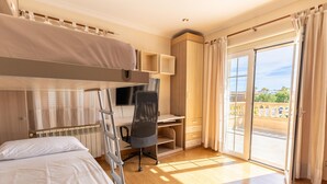 A hotel room with a bunk bed, a desk, a chair, a TV, and a balcony with a view. - Villa Mariela by NPMallorca (Sa Coma)