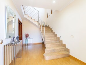 A staircase with beige steps and a metal railing, leading to an upper floor. - Villa Mariela by NPMallorca (Sa Coma)