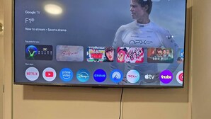 Ein an der Wand montierter Fernseher zeigt eine Streaming-Dienstanwendung mit verschiedenen App-Symbolen.