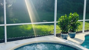 Ein Poolbereich mit freiem Blick auf die umliegende Natur und einen sonnigen Himmel.