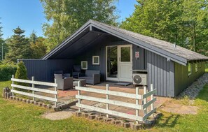 A small cabin with a porch, outdoor seating, and a door with a sign. - Stunning home in Toftlund with WiFi (Toftlund)