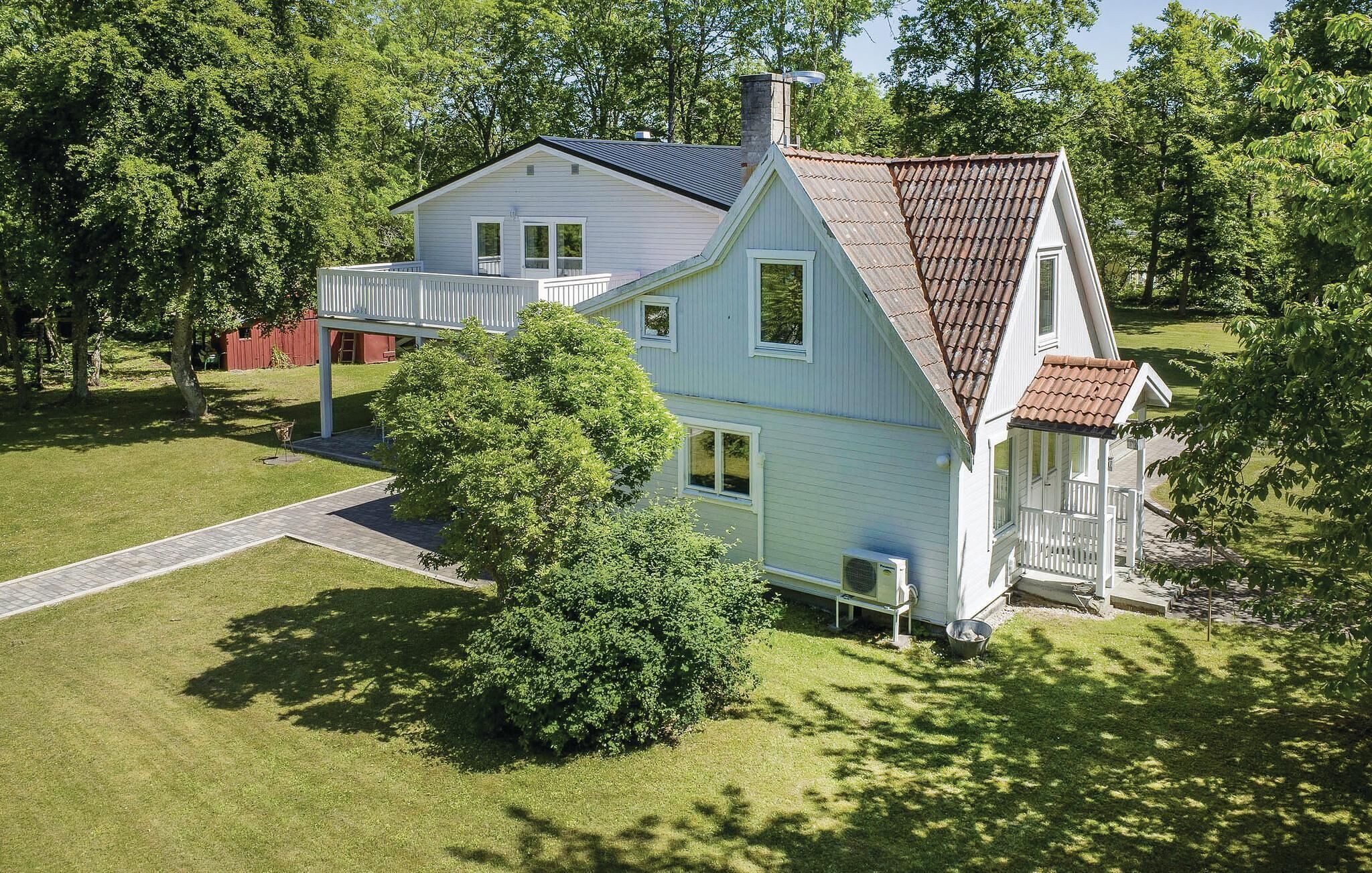 A two-story house with a covered porch and a chimney.