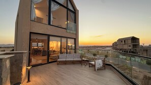 Un apartamento moderno con balcón, ventanas amplias y vistas a la ciudad.
