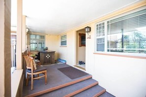 A room with a dining area, a kitchen, and a large window.