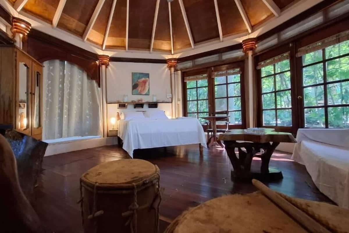 Una habitación con una cama, una mesa y una batería.