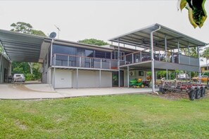 Ein modernes, zweistöckiges Haus mit überdachter Garage, einem Balkon und einer Satellitenschüssel.
