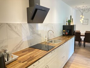 Eine moderne Küche mit einer Holzausziehtheke, einer integrierten Spüle und einer schwarzen Dunstabzugshaube.