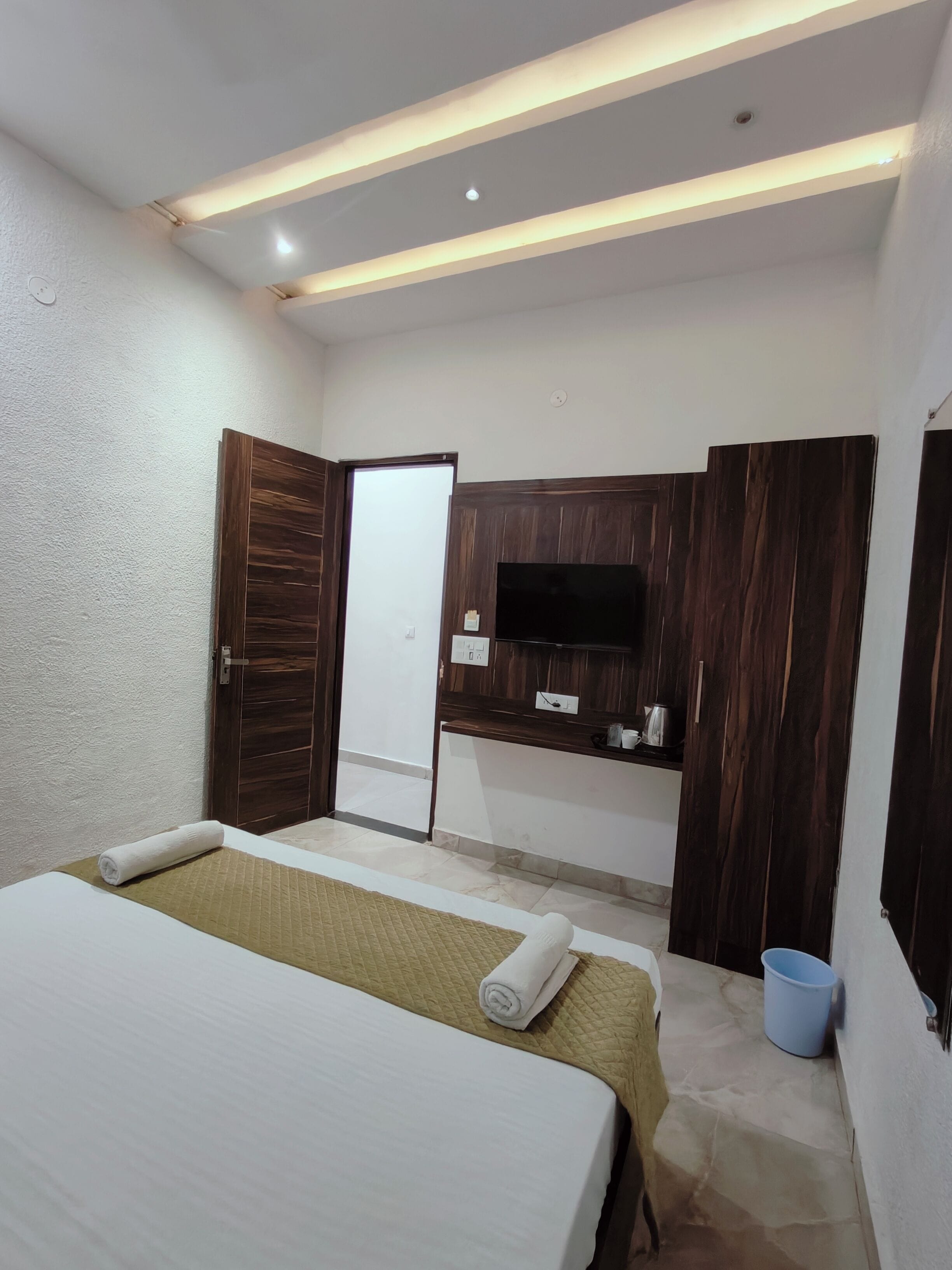 Une chambre d’hôtel équipée d’un lit, d’une télévision, d’une armoire et d’un bureau.