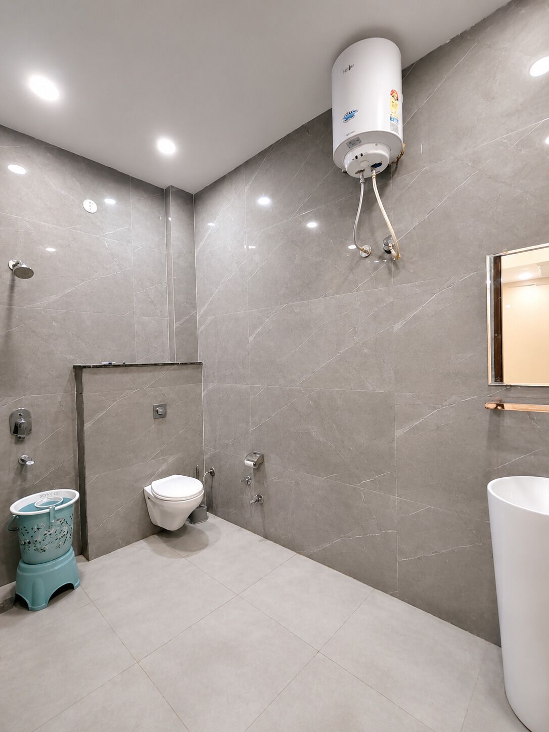 Un baño moderno con inodoro, bidé y calentador de agua mural.