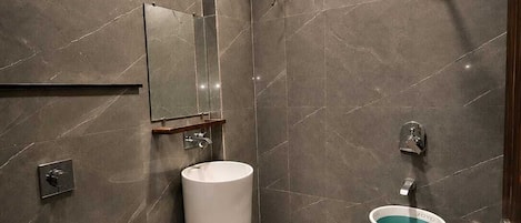 A modern bathroom with a toilet, sink, and shower.