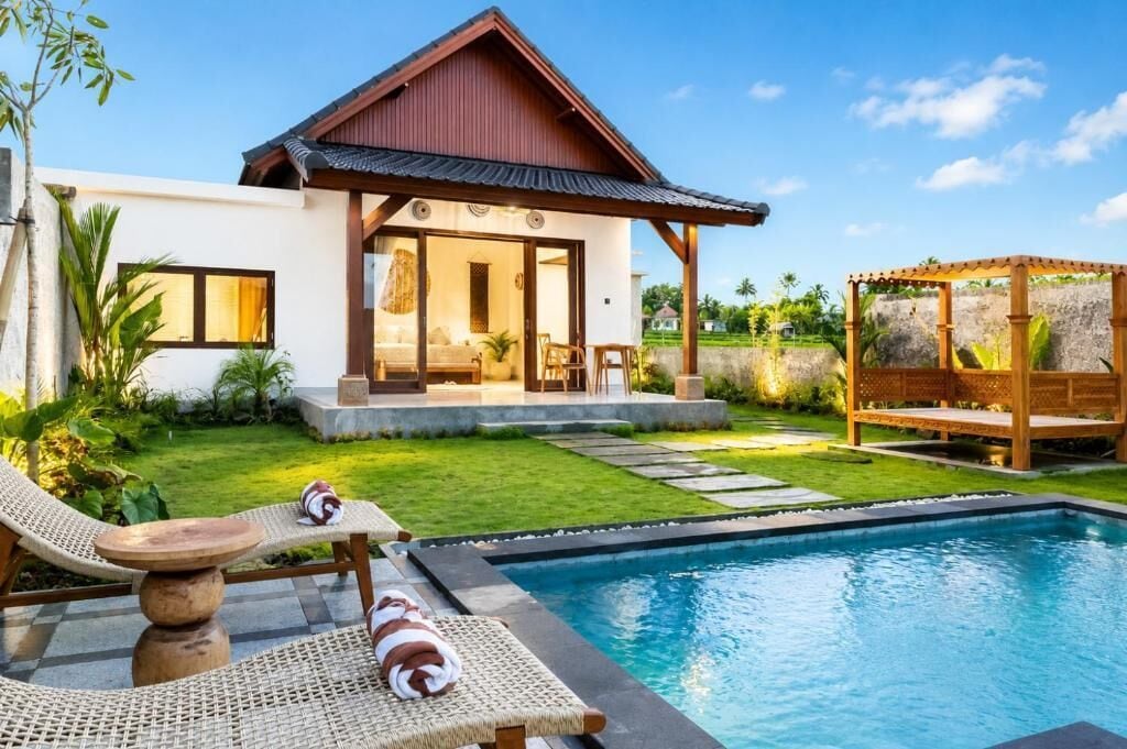 A modern house with a pool, a covered outdoor seating area, and a well-maintained lawn.