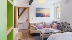 A cozy room with a sofa, a table, a painting, and a staircase. - Alte Scheune by Interhome (Idstein)