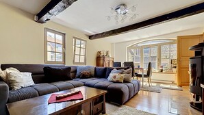 A living room with a dark sofa, wooden coffee table, and a fireplace. - Alte Scheune by Interhome (Idstein)