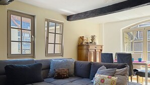 A living room with a sectional sofa, a wooden cabinet, and two windows. - Alte Scheune by Interhome (Idstein)