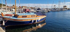 A marina with various boats docked, a clear sky, and buildings in the background. - Apartment T3 3*, 200m from the beach, 57m², 2 bedrooms, air conditioning, parking, terrace, balcony, shops (Bormes-les-Mimosas)