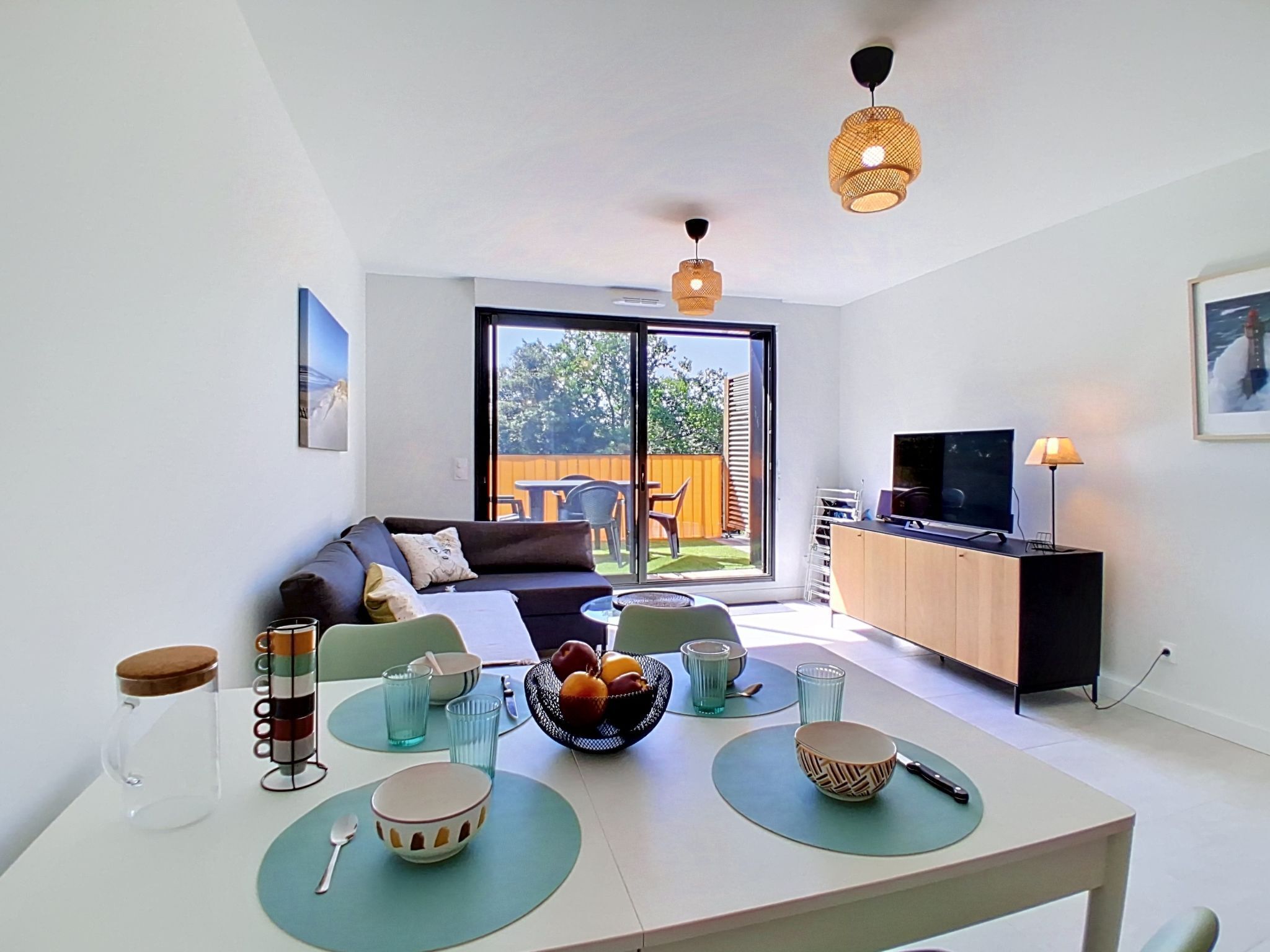 Una sala moderna con un sofá, una mesa de comedor y un televisor.