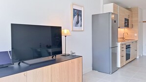 Eine moderne Küche mit Flachbildfernseher, einer Lampe und einem gerahmten Bild an der Wand.
