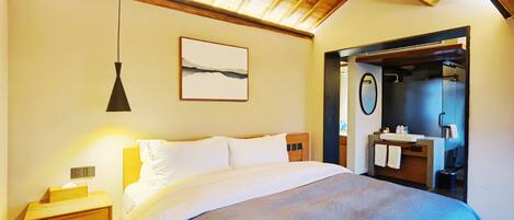 A bedroom with a bed, bedside table, and a mirror.