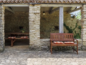 A stone building with a wooden bench and a table with cushions. - Villa Krase by Interhome (Svetvinčenat)