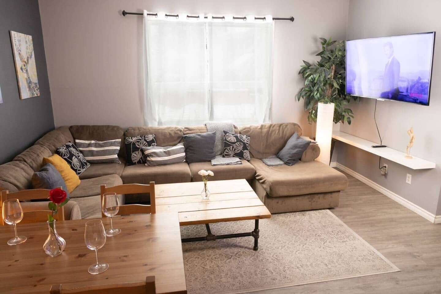 A living room with a sofa, a coffee table, and a TV.