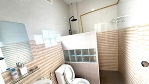 A bathroom with a sink, toilet, and shower. - Cozy Corner Hotel (Vang Vieng)