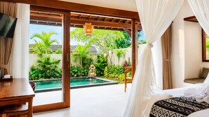 Un dormitorio con vistas a una piscina y abundante vegetación.