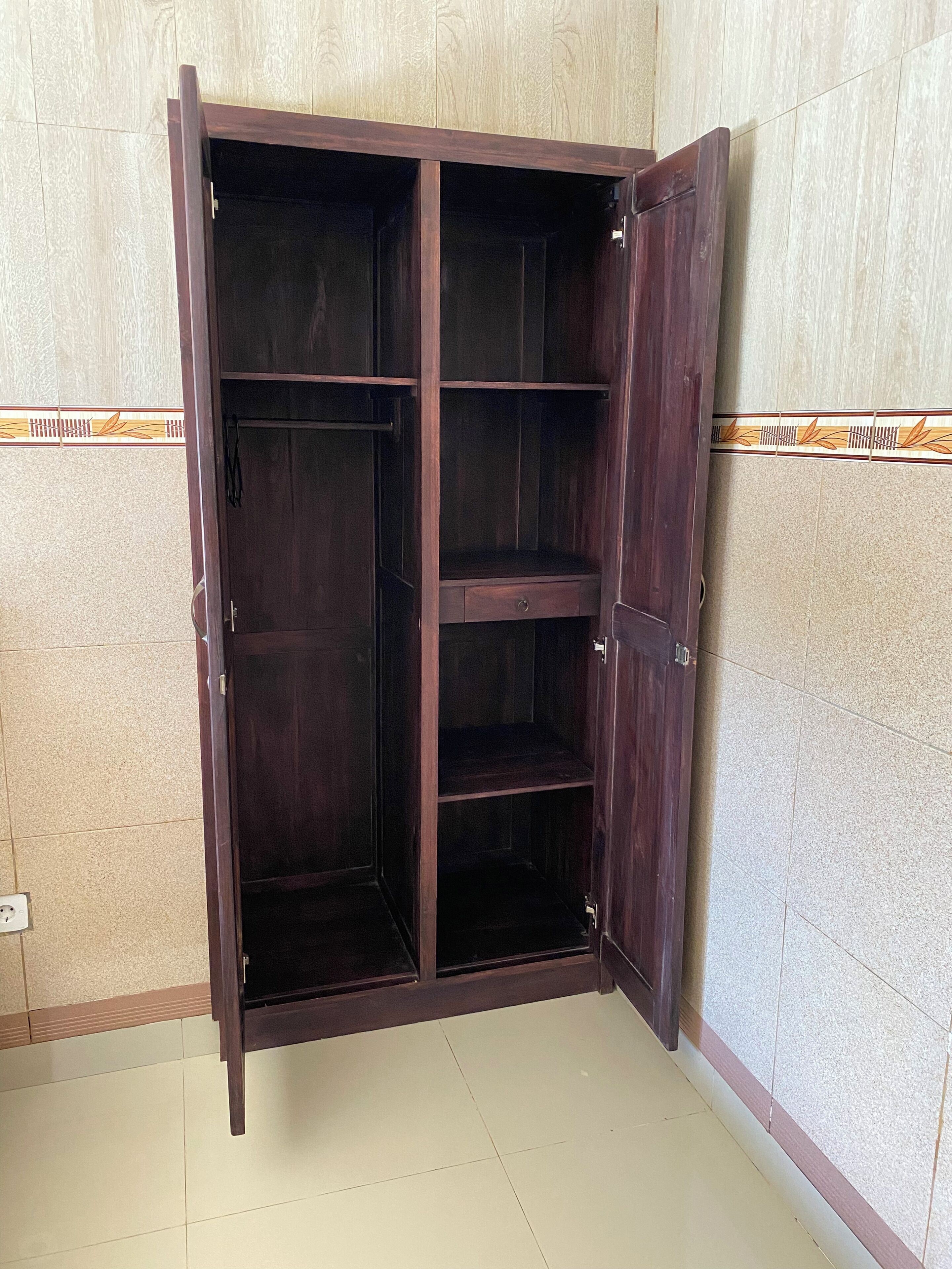 A corner wardrobe with open doors, revealing multiple shelves and a hanging rod.